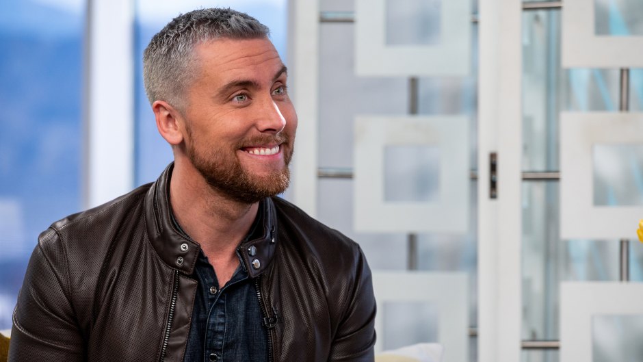 Lance Bass Smiles With Grey Hair and Red Beard in Leather Jacket