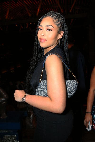 Jordyn Woods Stands Turned Away From the Camera in a Black Dress and Blue Jean Fendi Bag