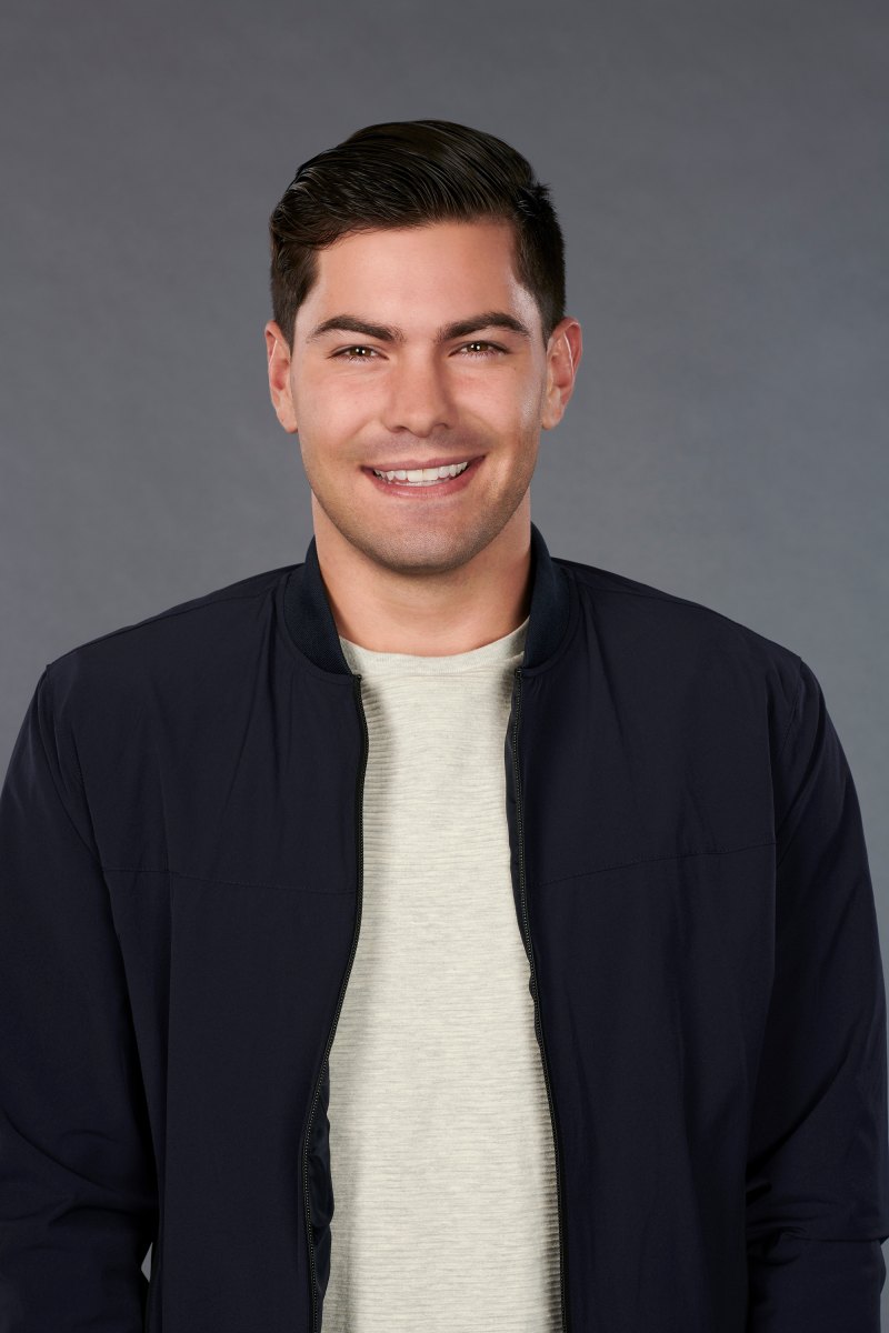 Bachelorette Contestant Dylan Headshot in White Tshirt and Black Bomber Jacket Smiling in Cast Photo