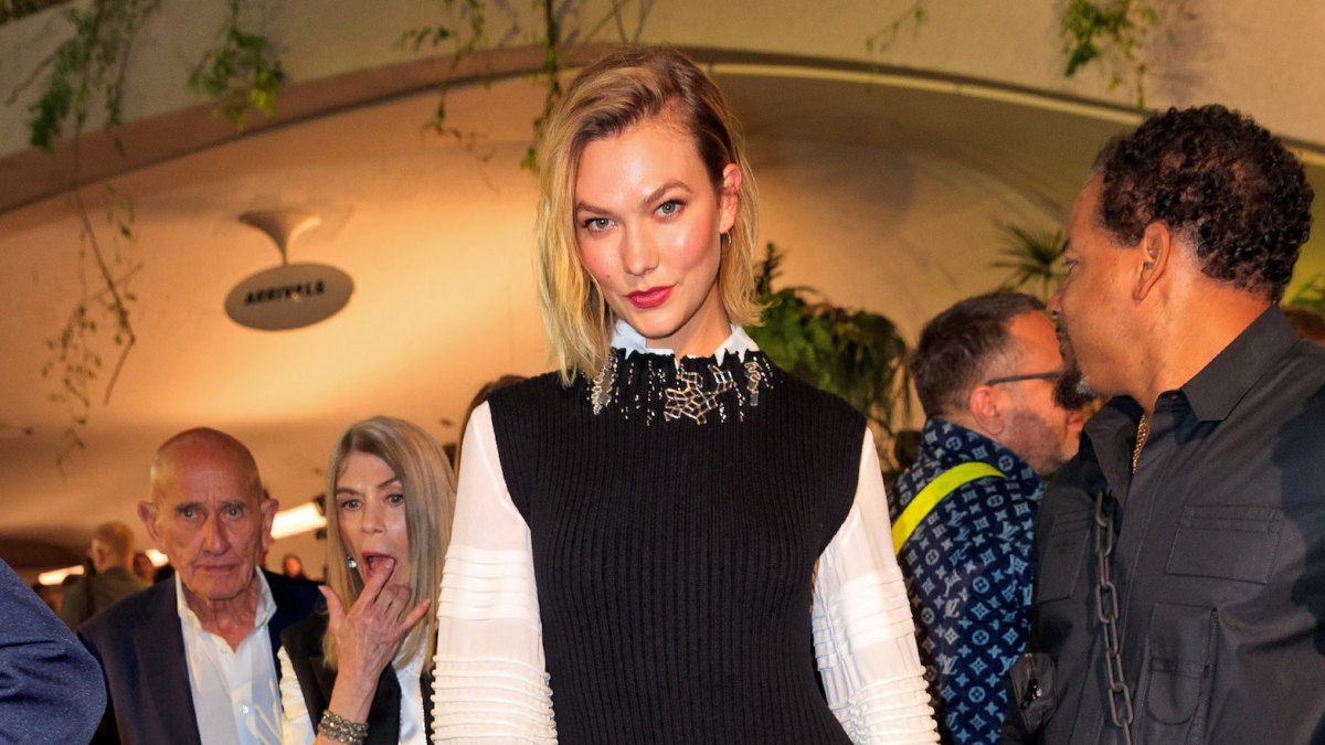 Karlie Kloss Smiles With Short Blonde Hair White Blouse and Black Sweater Dress