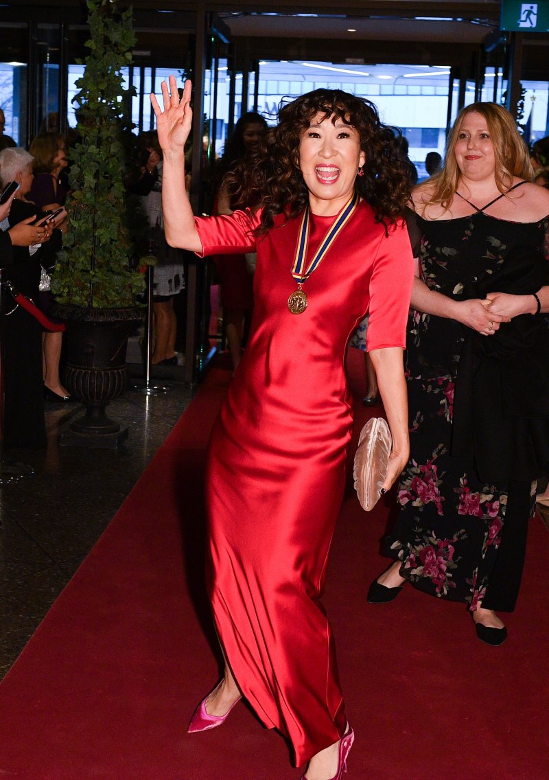 Sandra Oh Smiles and Waves in a Red Silky Dress