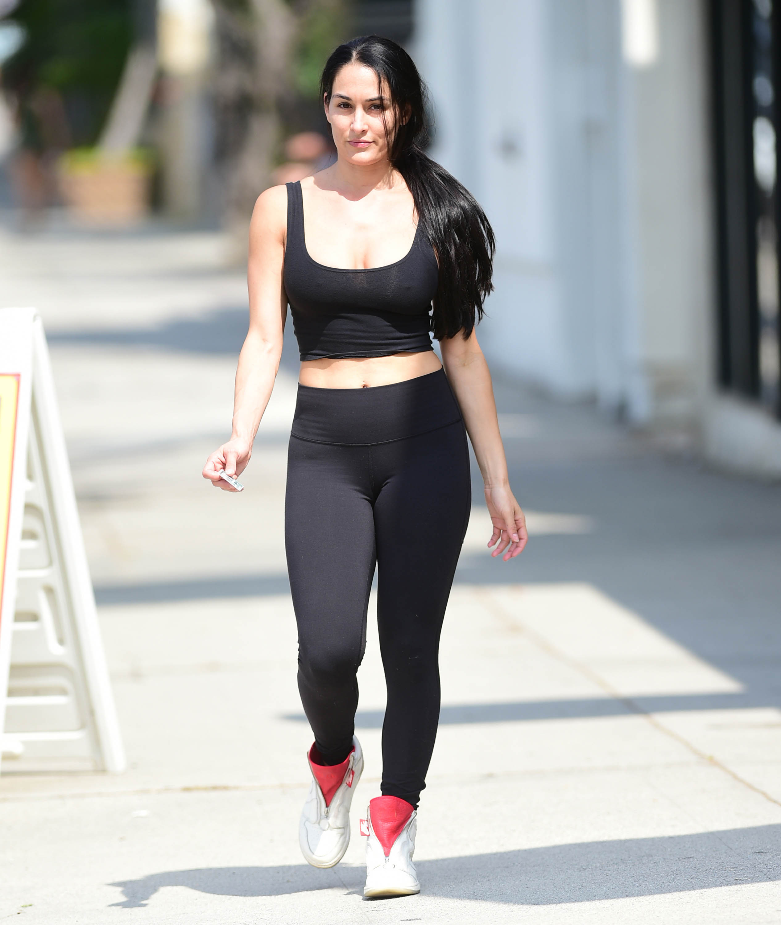 Nikki Bella Wears Black Yoga Pants and Black Sports Bra With Red High Top Sneakers