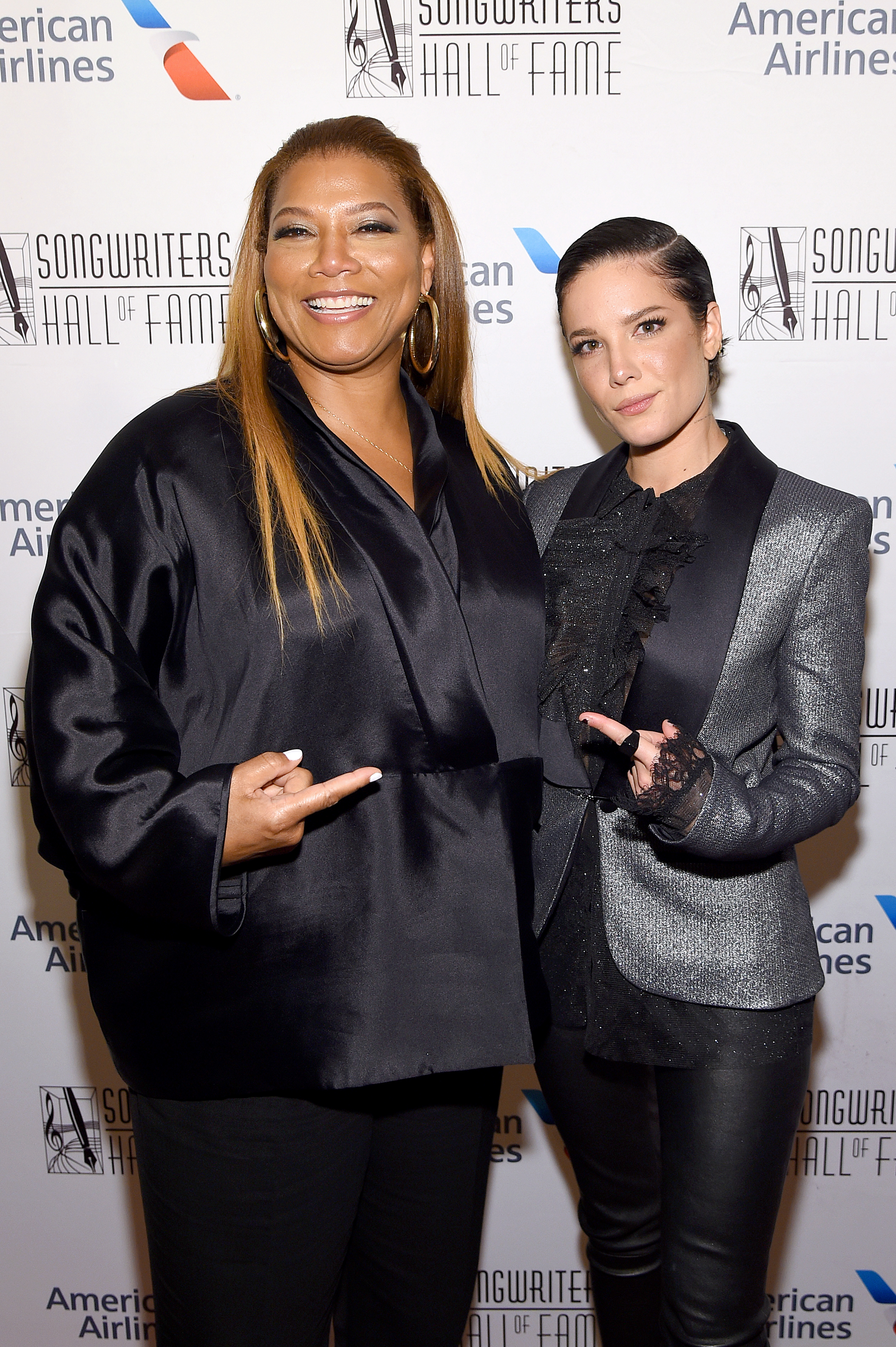 Halsey Smiles in Silver Suit Jacket and Black Blouse and and Points at Queen Latifah in a Satin Black Blouse