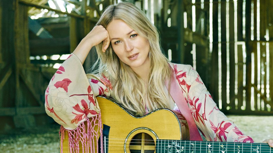 Jewel Sitting with a Guitar on a Chair in a Barn