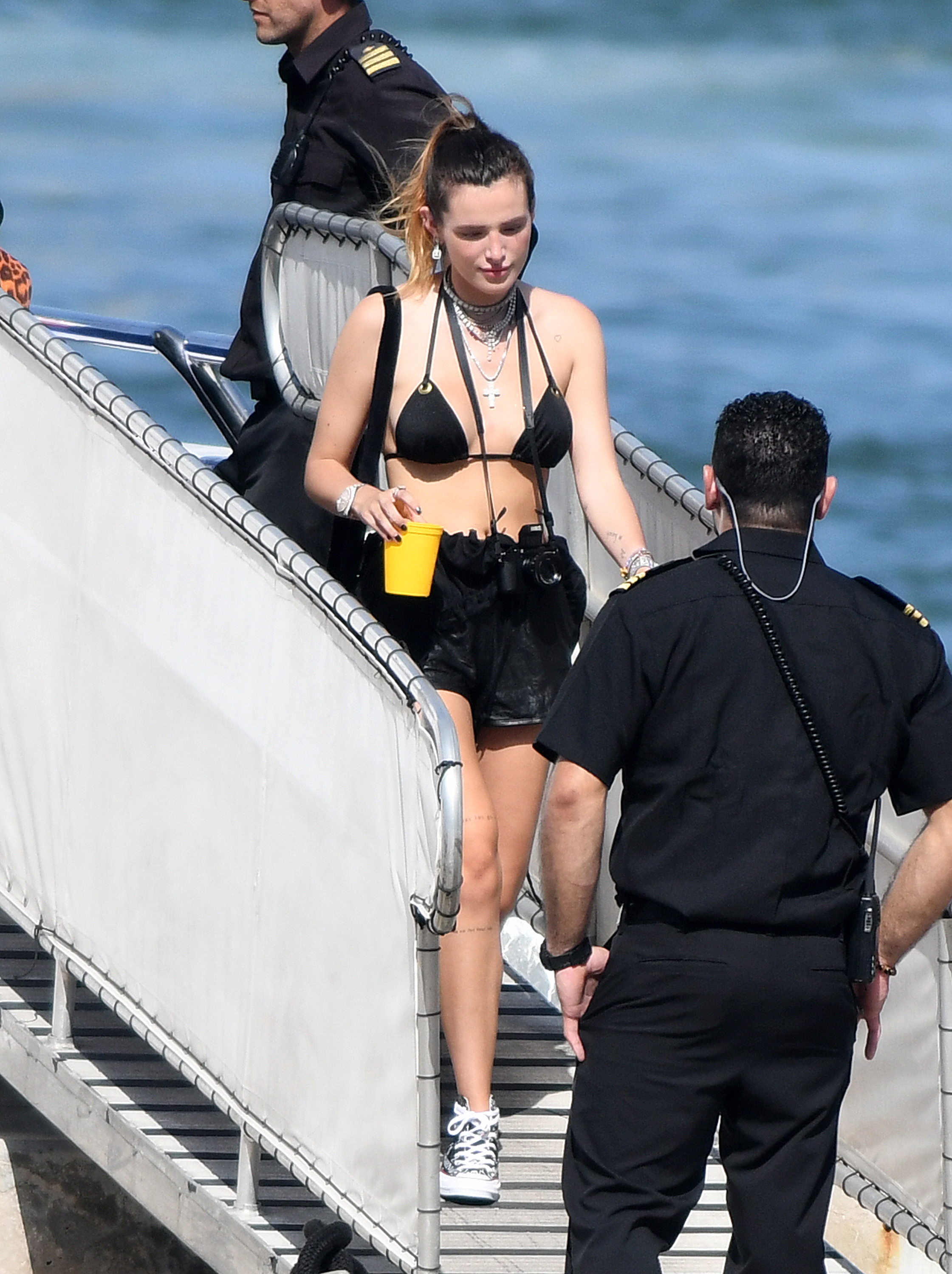 Bella Thorne in a Black Bikini Top and Black Shorts Holding a Drink