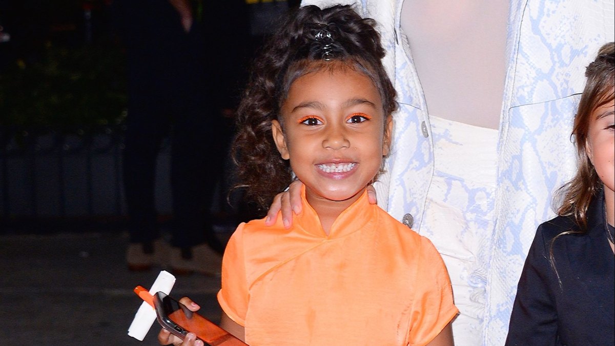 North West Smiles in Orange Dress
