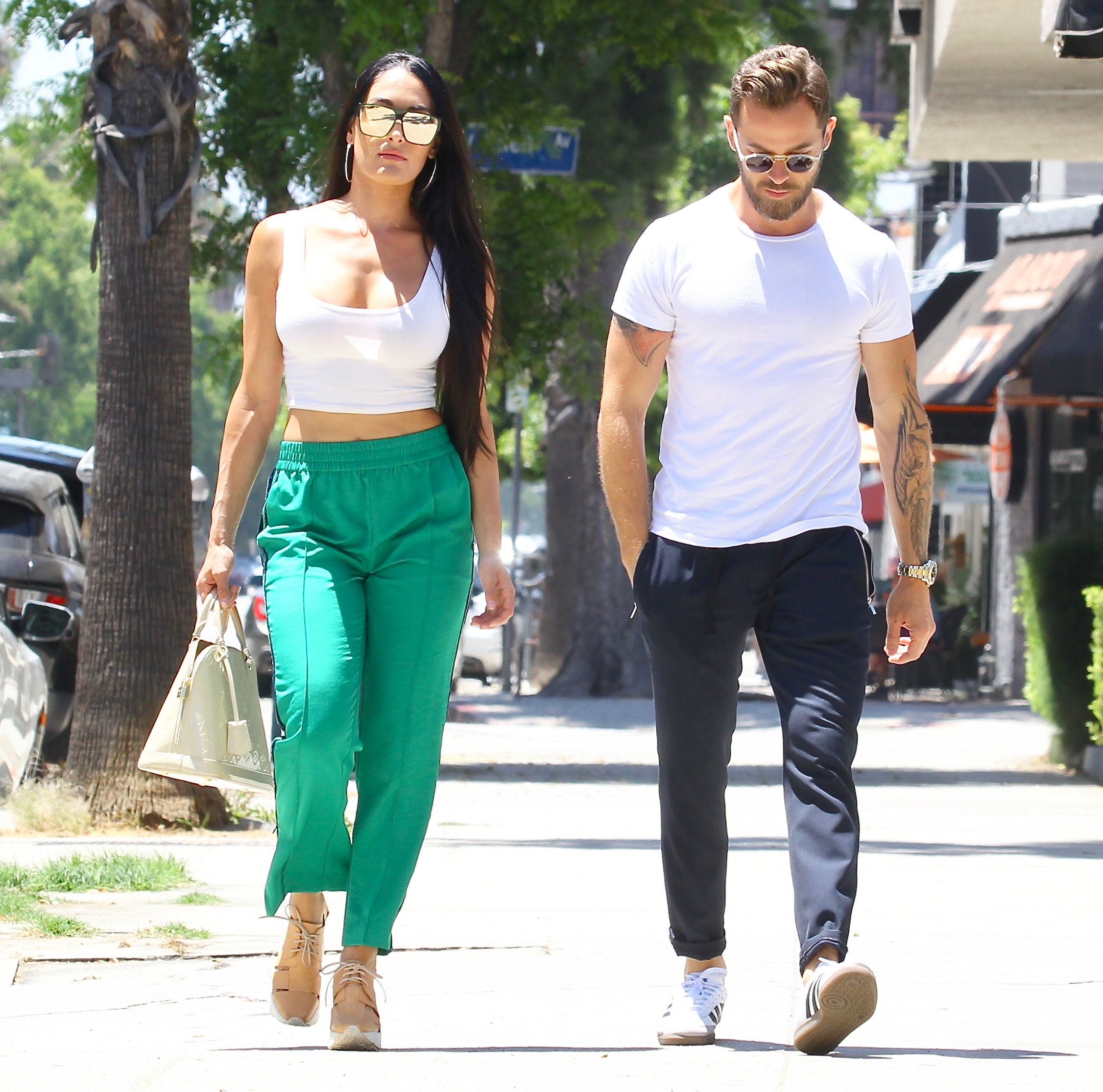 Nikki Bella in Green Track Pants and White Crop Top Running Errands With Artem Chigvintsev in Jeans and White Tshirt