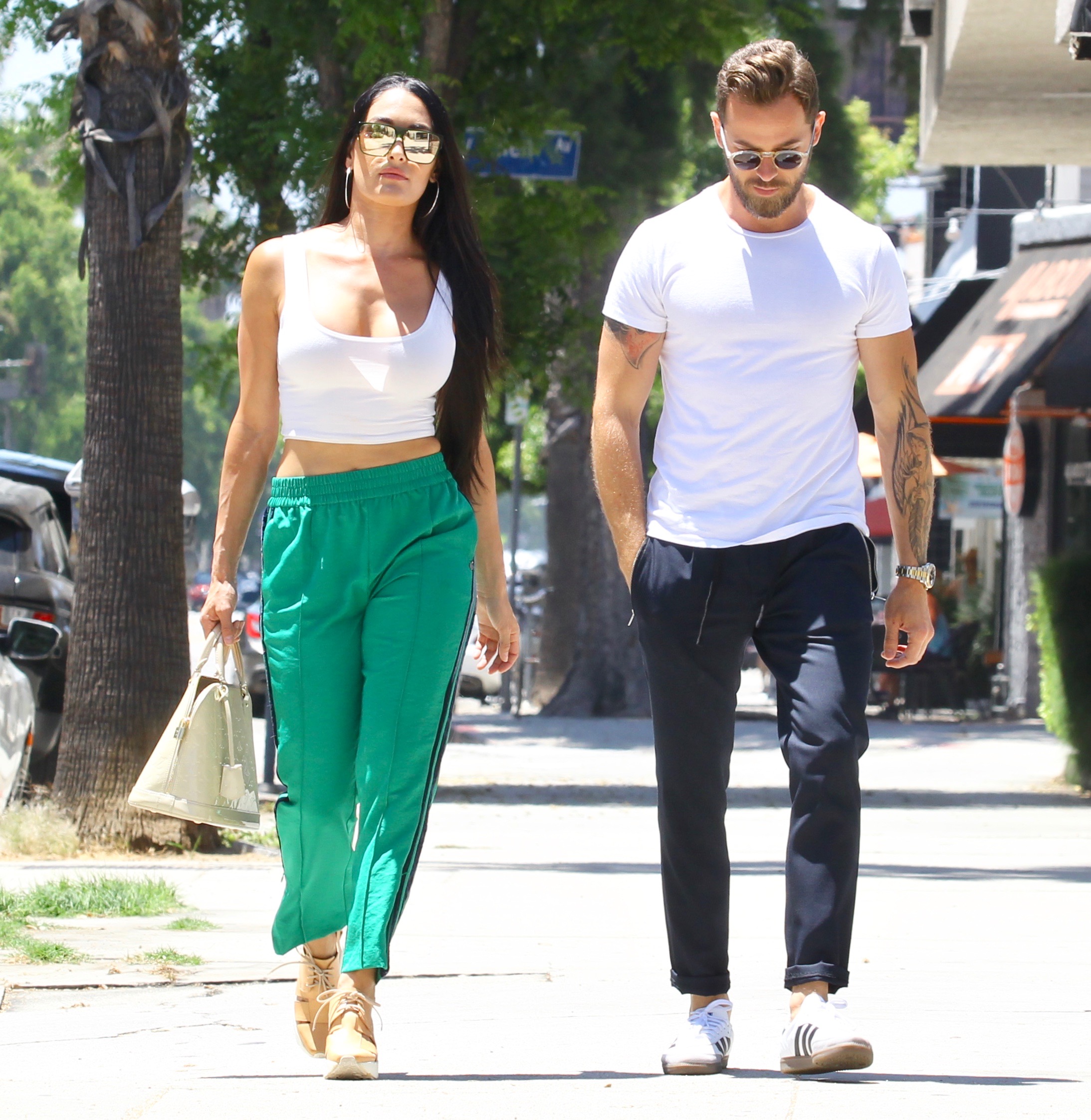 Nikki Bella in Green Track Pants and White Crop Top Running Errands With Artem Chigvintsev in Jeans and White Tshirt