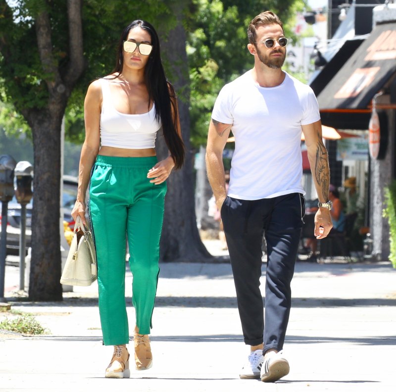 Nikki Bella in Green Track Pants and White Crop Top Running Errands With Artem Chigvintsev in Jeans and White Tshirt