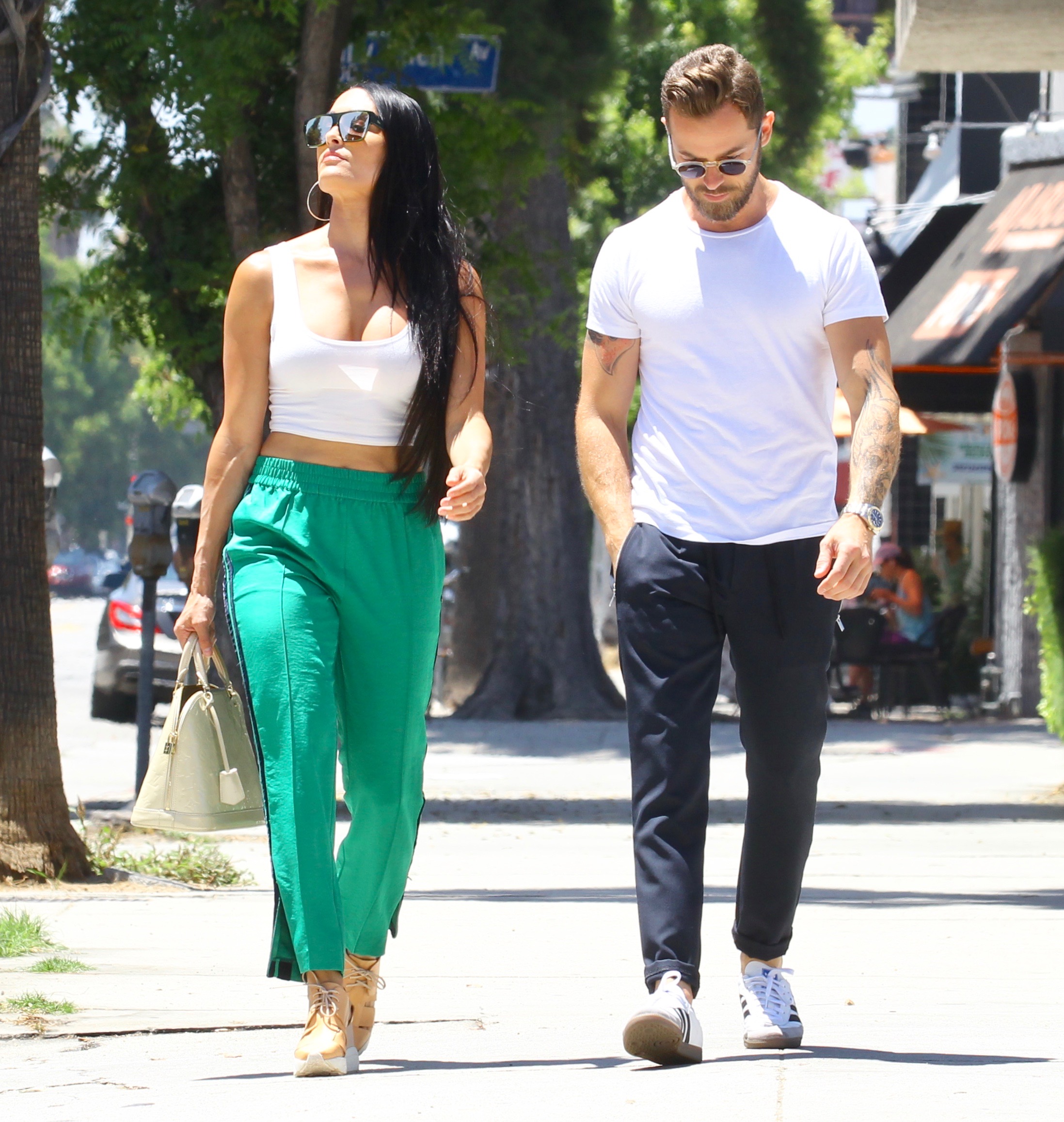 Nikki Bella in Green Track Pants and White Crop Top Running Errands With Artem Chigvintsev in Jeans and White Tshirt
