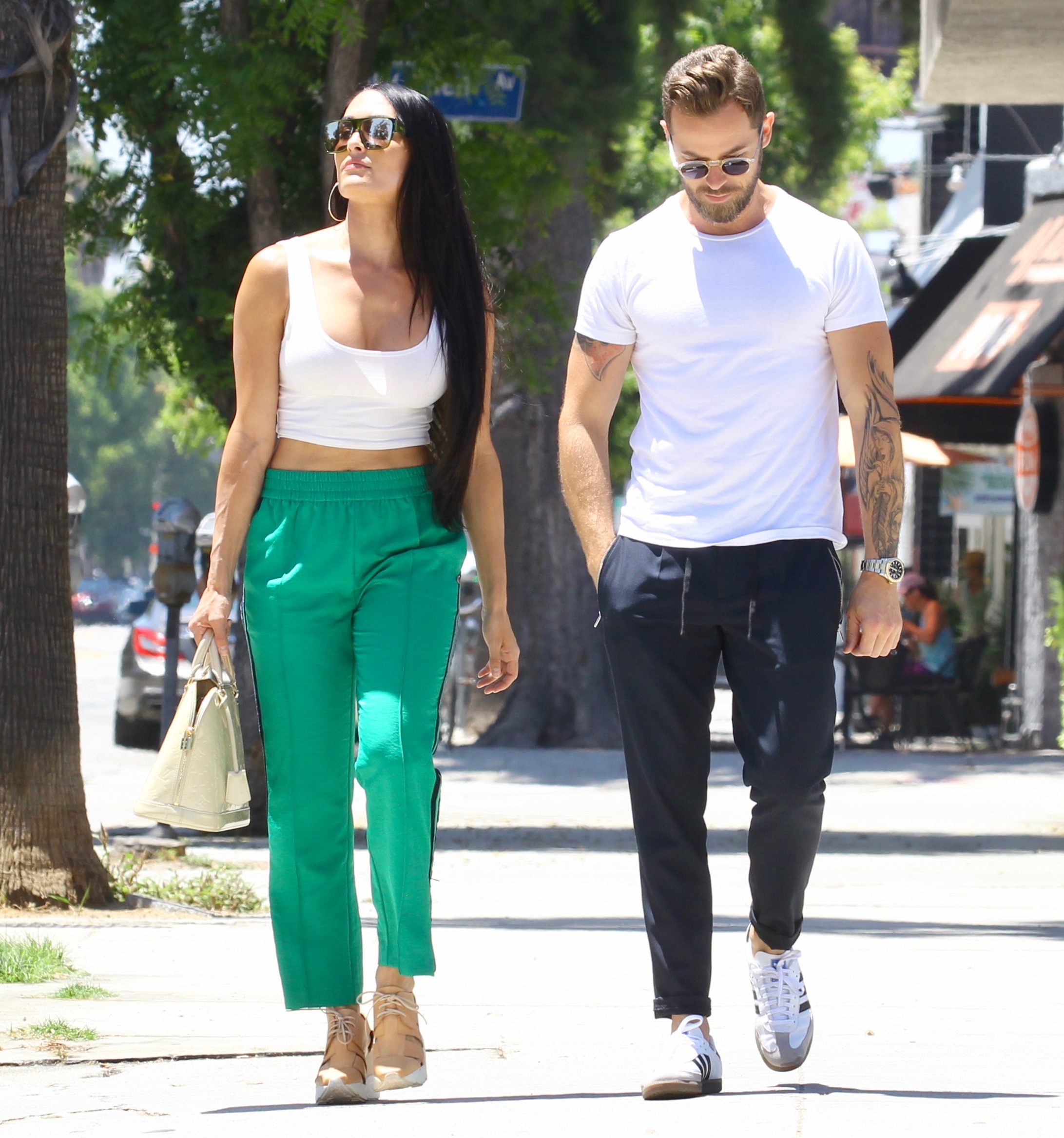 Nikki Bella in Green Track Pants and White Crop Top Running Errands With Artem Chigvintsev in Jeans and White Tshirt