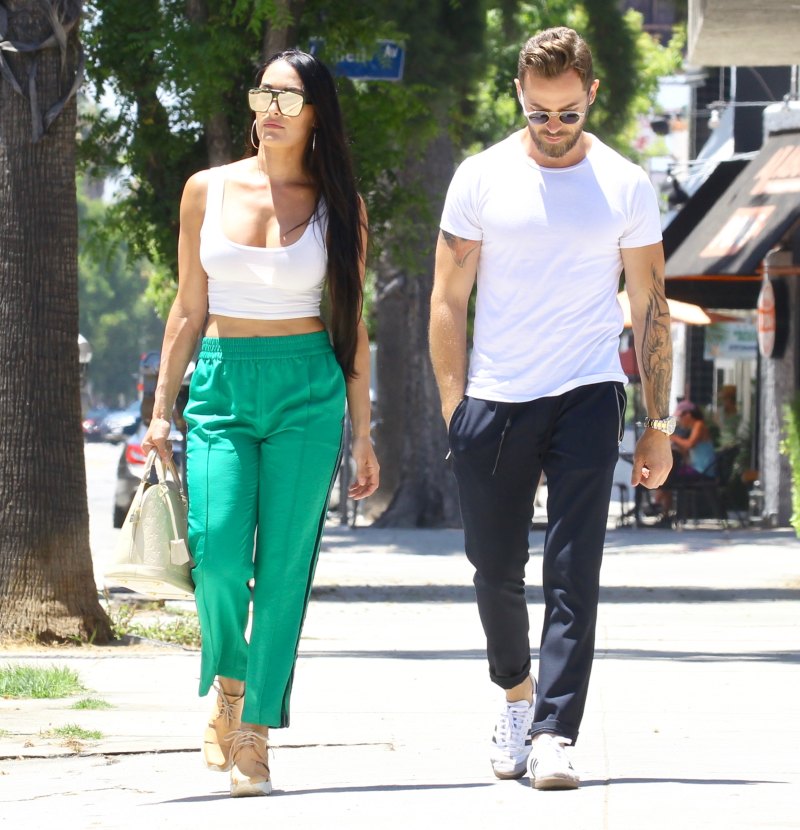 Nikki Bella in Green Track Pants and White Crop Top Running Errands With Artem Chigvintsev in Jeans and White Tshirt