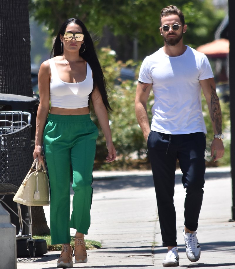 Nikki Bella in Green Track Pants and White Crop Top Running Errands With Artem Chigvintsev in Jeans and White Tshirt