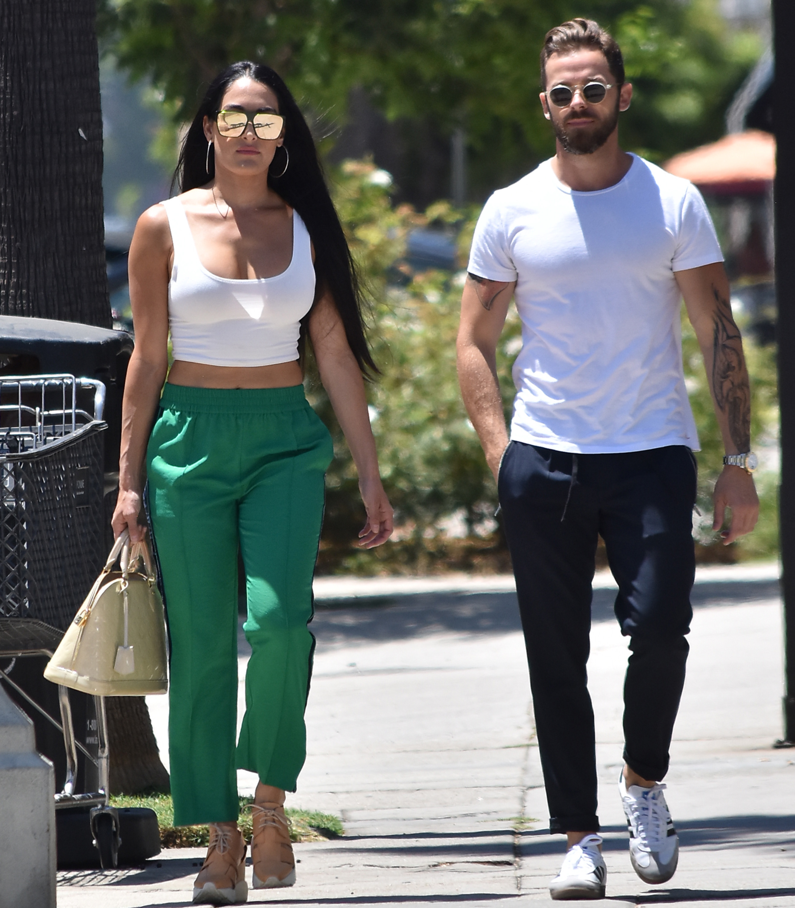 Nikki Bella in Green Track Pants and White Crop Top Running Errands With Artem Chigvintsev in Jeans and White Tshirt