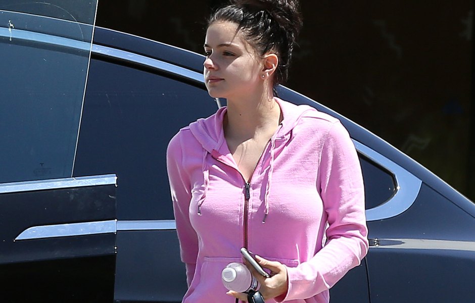 Ariel Winter walking in a pink sweater and denim short shorts