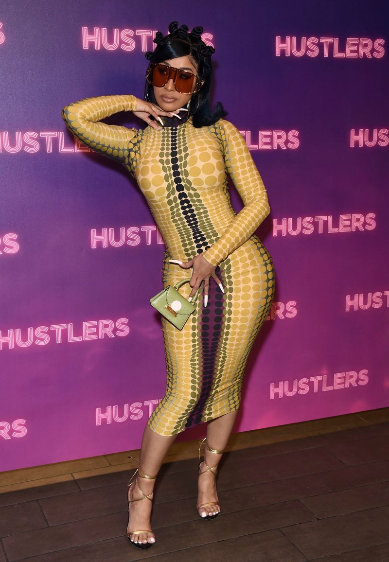 Cardi B posing in a yellow jumpsuit