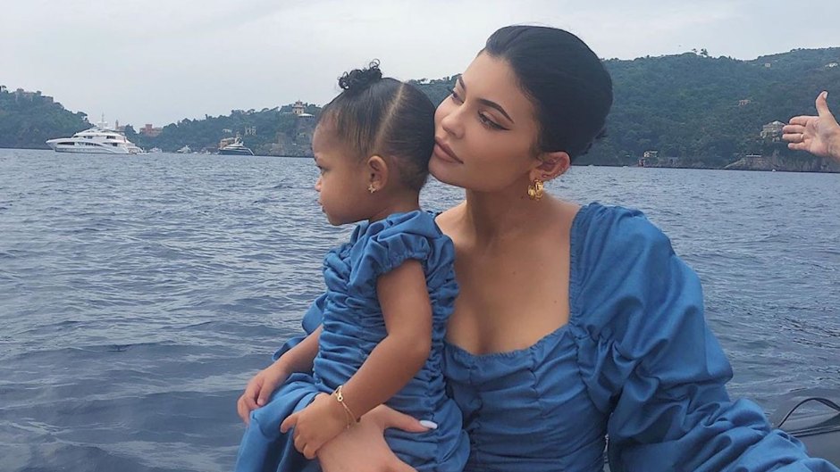Kylie Jenner and Stormi Webster matching blue ruffle dresses on a boat in italy