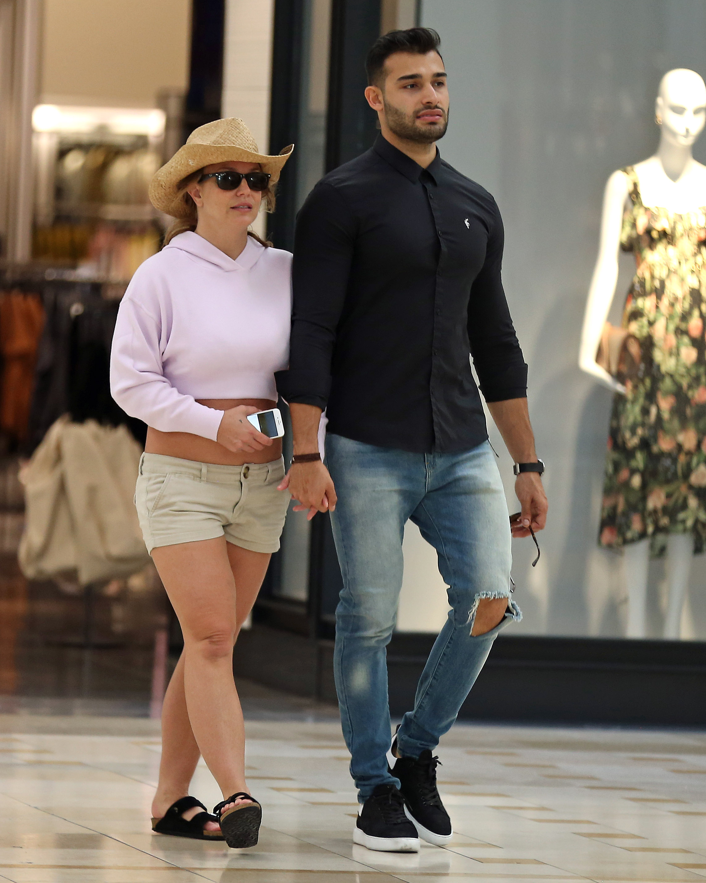 Britney Spears and boyfriend Sam Asghari hold hands while walking in the mall