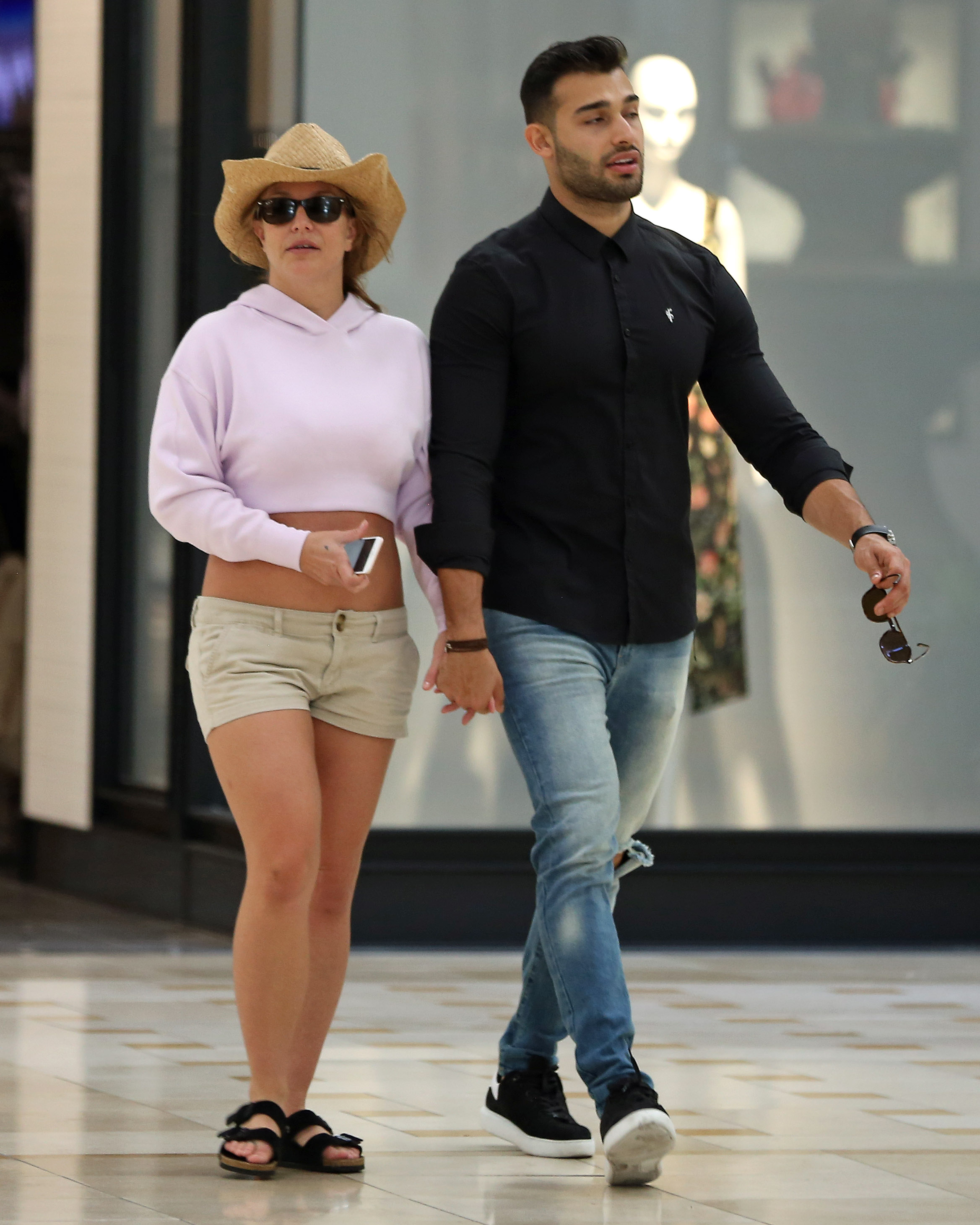 Britney Spears and boyfriend Sam Asghari hold hands while walking in the mall