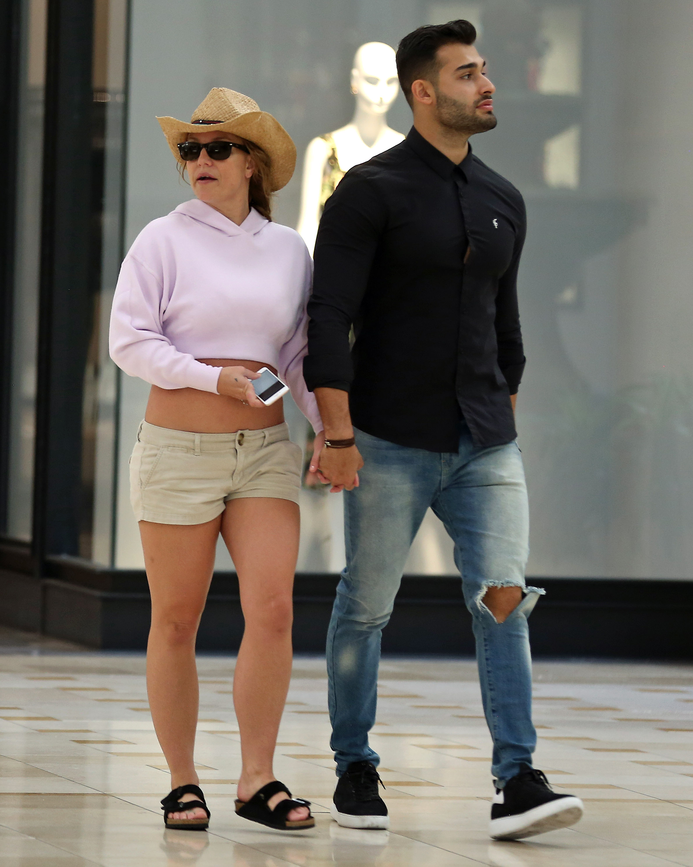 Britney Spears and boyfriend Sam Asghari hold hands while walking in the mall