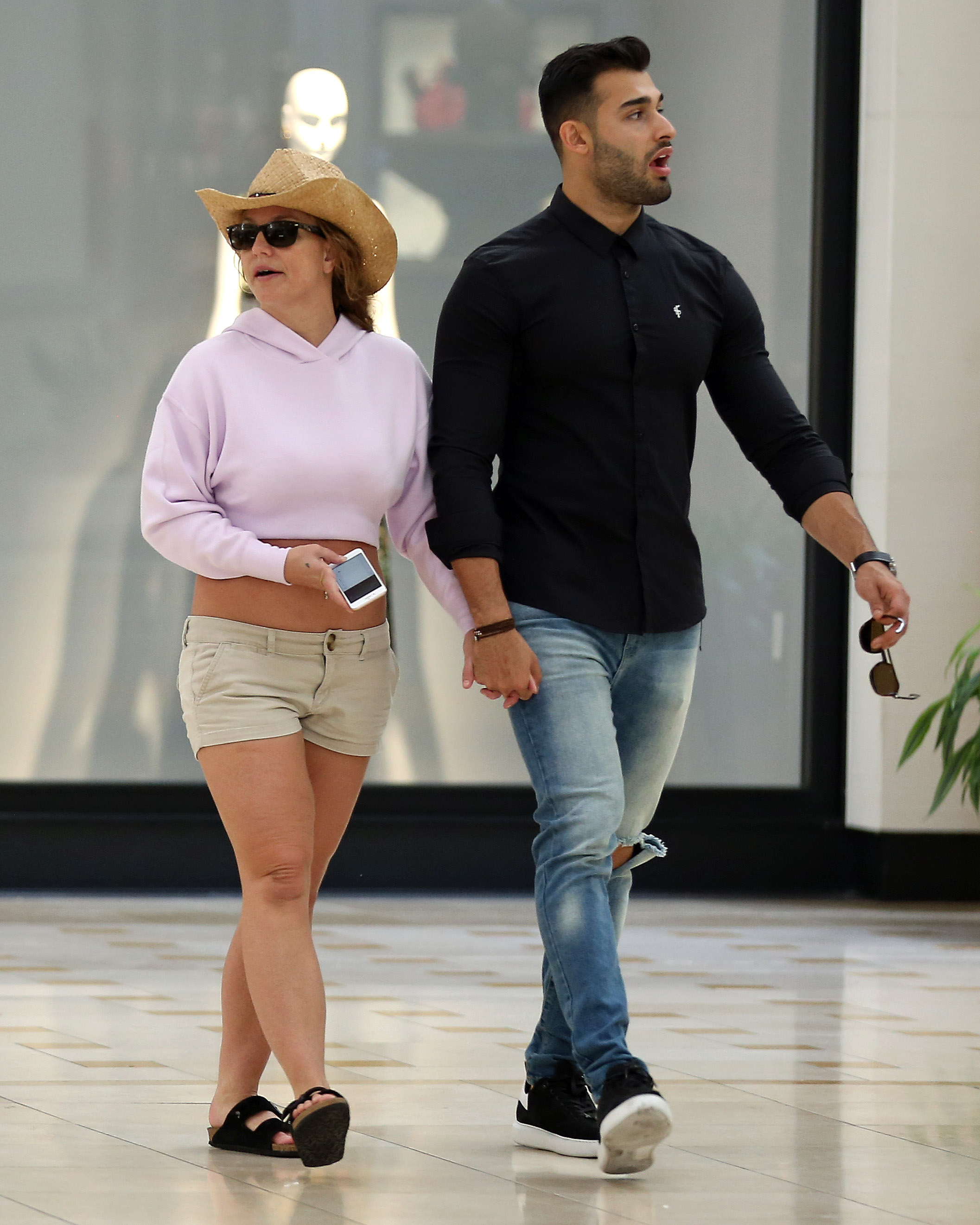 Britney Spears and boyfriend Sam Asghari hold hands while walking in the mall