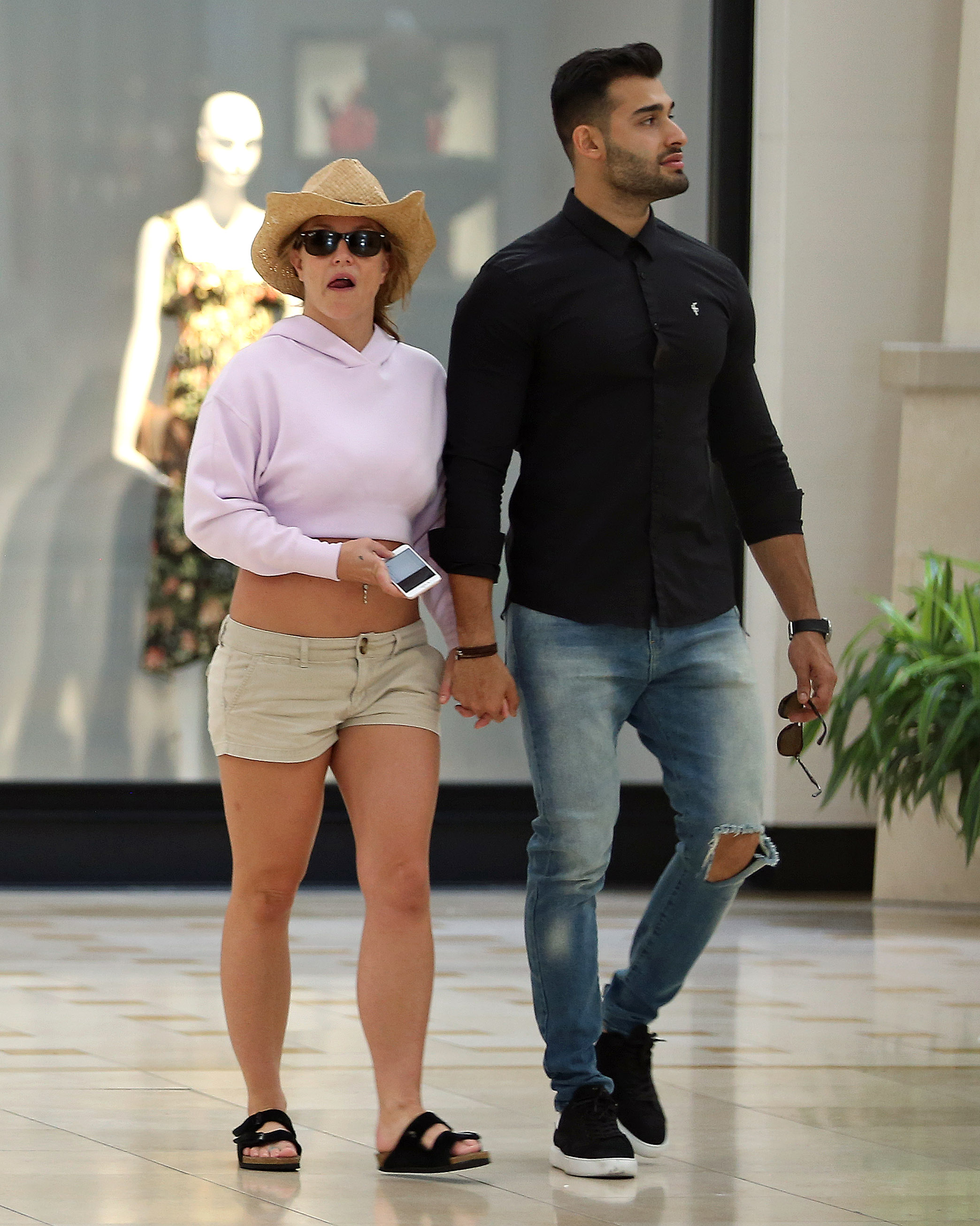 Britney Spears and boyfriend Sam Asghari hold hands while walking in the mall