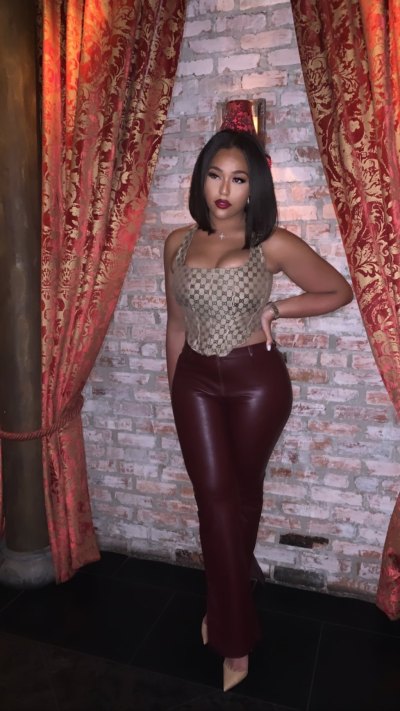 Jordyn Woods posing in a Gucci bustier, leather pants and nude heels
