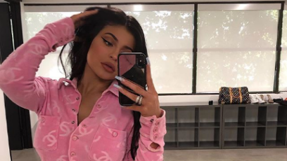 Kylie Jenner taking a selfie in a pink Chanel shirt