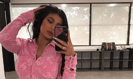 Kylie Jenner taking a selfie in a pink Chanel shirt