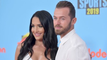 Nikki Bella and Artemchigvintsev posing and wearing all white