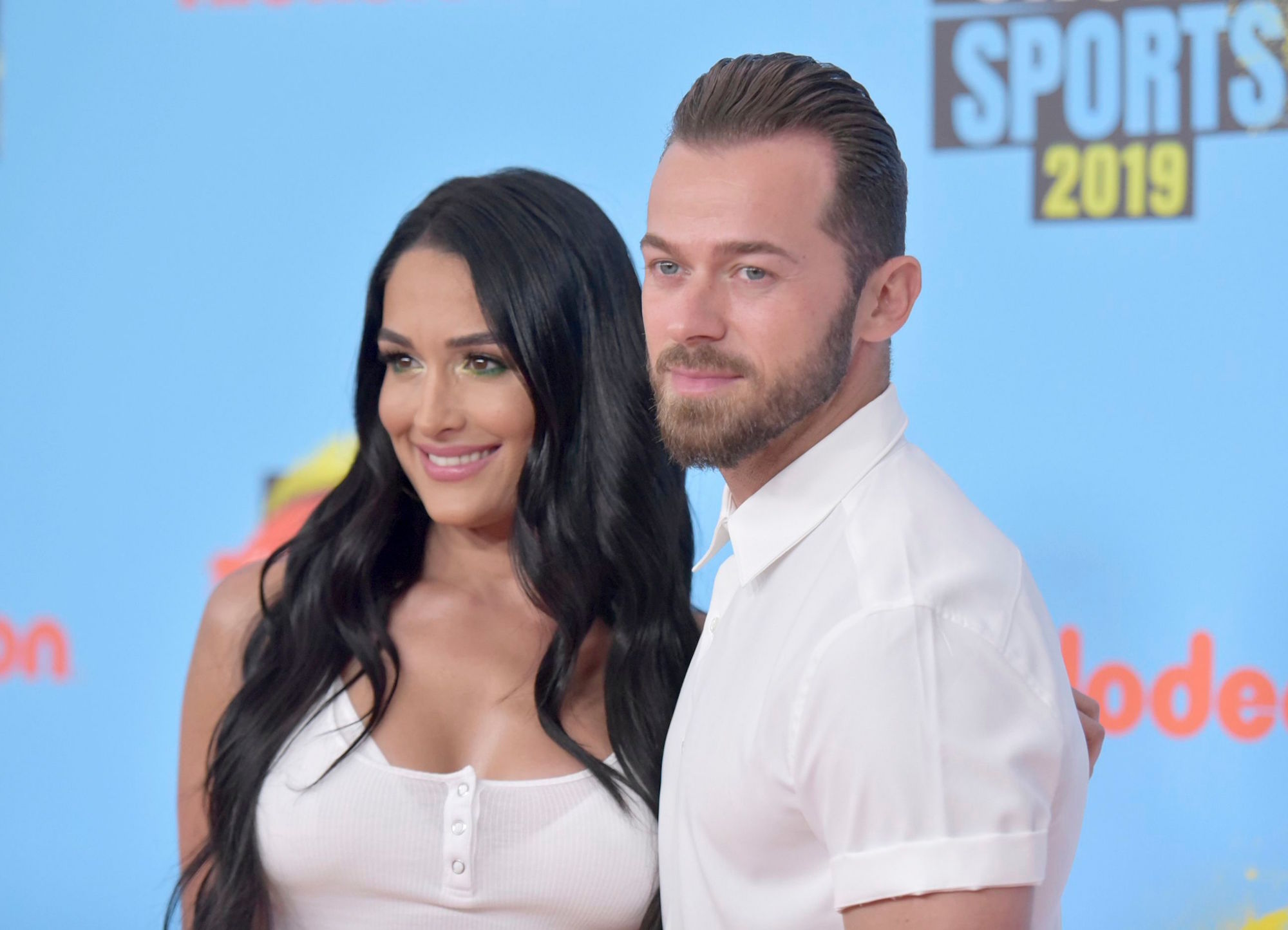 Nikki Bella and Artemchigvintsev posing and wearing all white