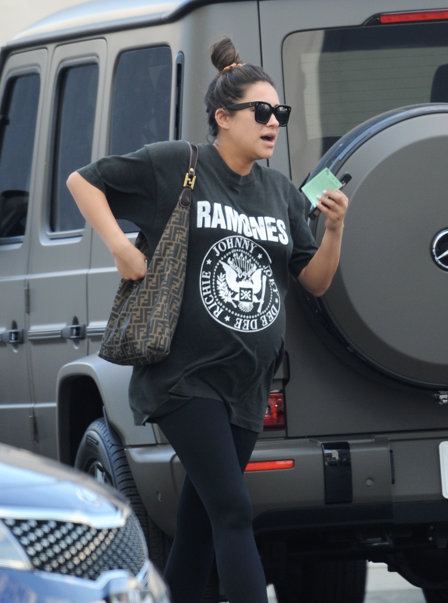 Pregnant Shay Mitchell wearing a Ramones T-Shirt, black leggings, sunglasses and white sneakers