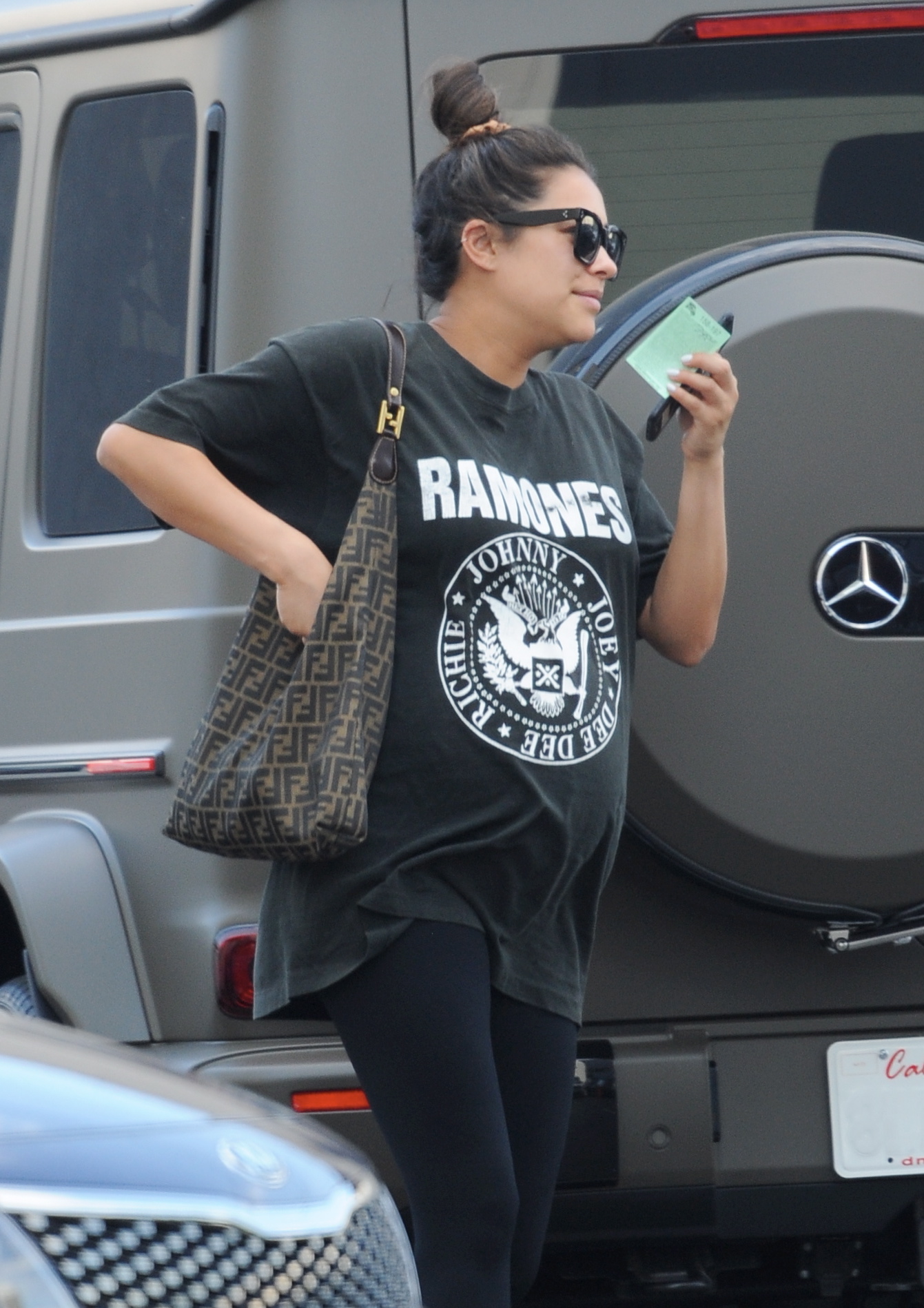 Pregnant Shay Mitchell wearing a Ramones T-Shirt, black leggings, sunglasses and white sneakers