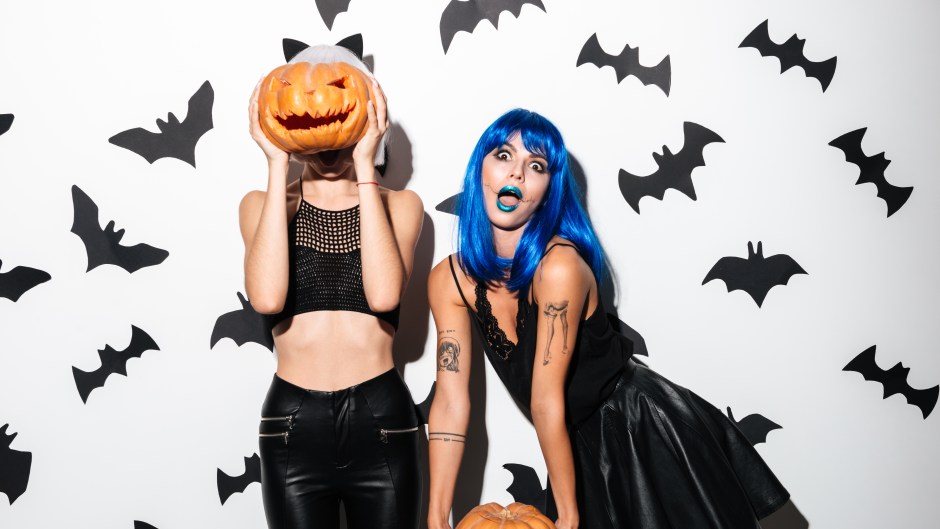 Two Women in Hallowen Costumes Holding Pumpkins