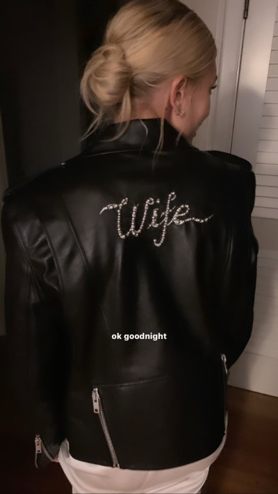 Hailey Baldwin wearing a leather jacket that says "wife" over her wedding dress