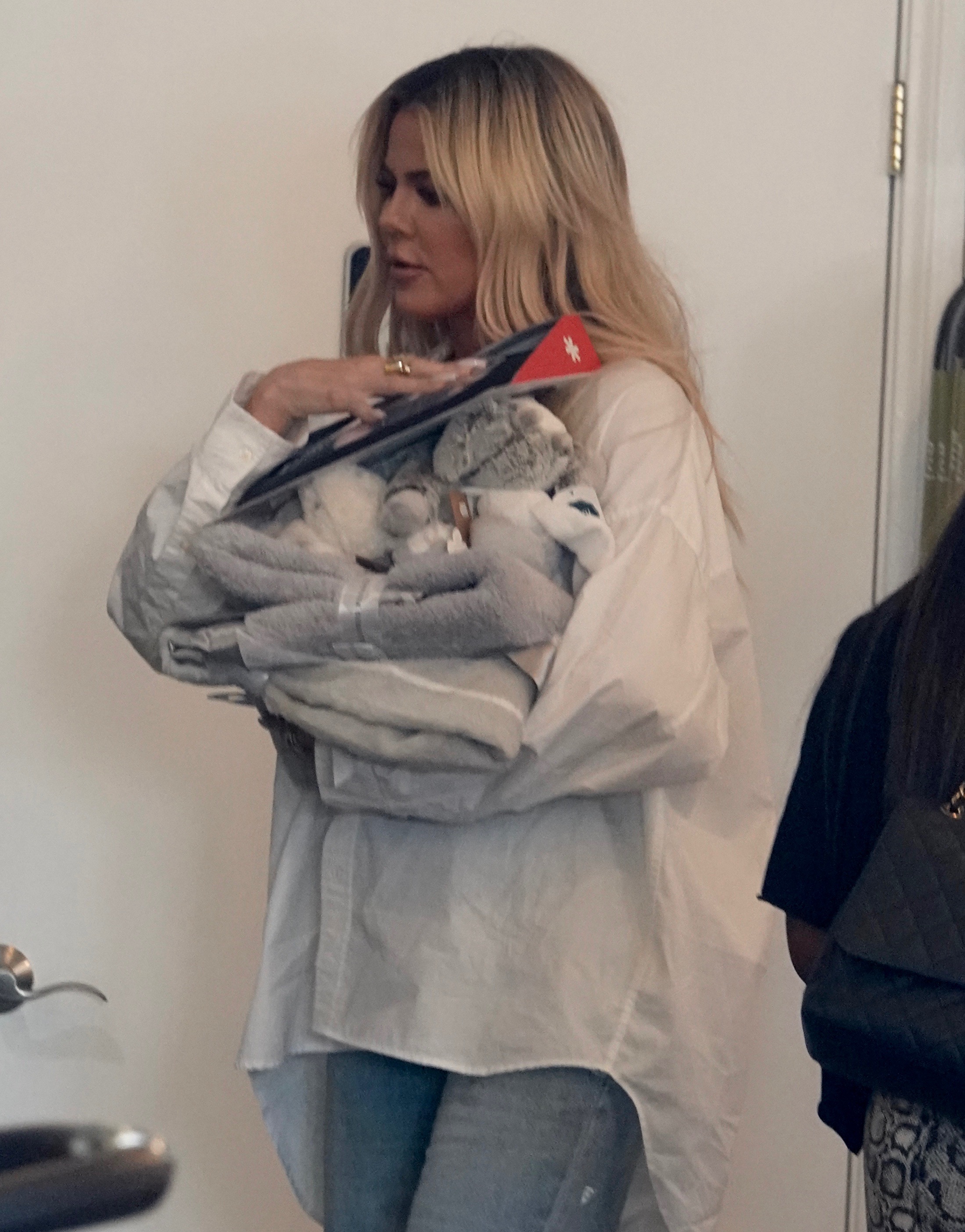 Khloe Kardashian shopping for baby supplies in jeans and a white blouse