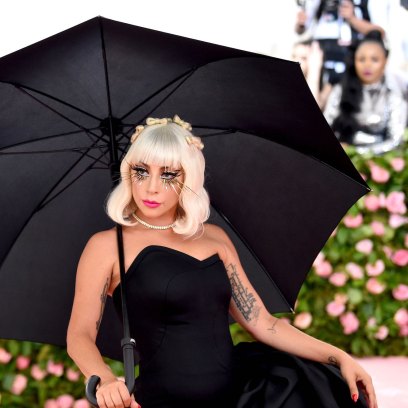 Lady Gaga in a black dress carrying an umbrella at the 2019 Met Gala