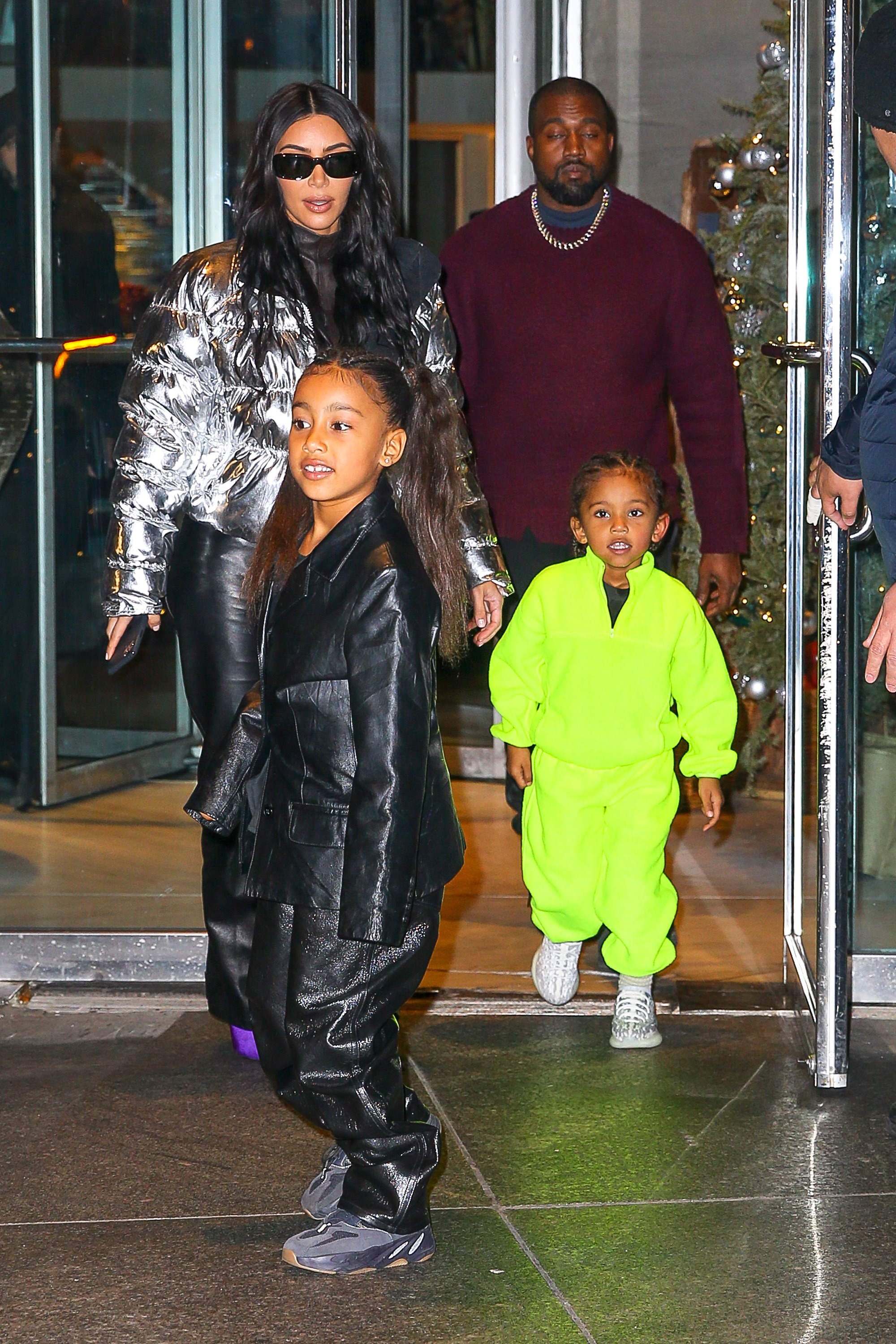 North West in Black Coat and Saint West in Lime Green Jumpsuit in NYC