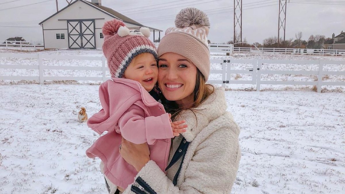 Bachelor Alum Jade Roper Wears Winter Coat and Hat With Puffball on Top While She Holds Daughter Emmy in Pink Jacket and Hat