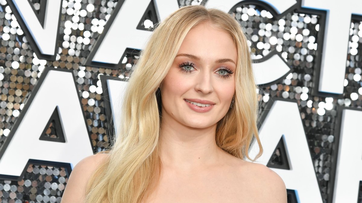 Sophie Turner Smiles in Pink Strapless Dress and Wavy Blonde Hair