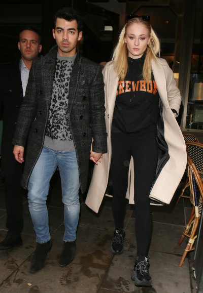 Joe Jonas Wears Jeans a Leopard Print Sweater and Long Coat Holding Hands With Wife Sophie Turner in Black Sweats and Tan Coat