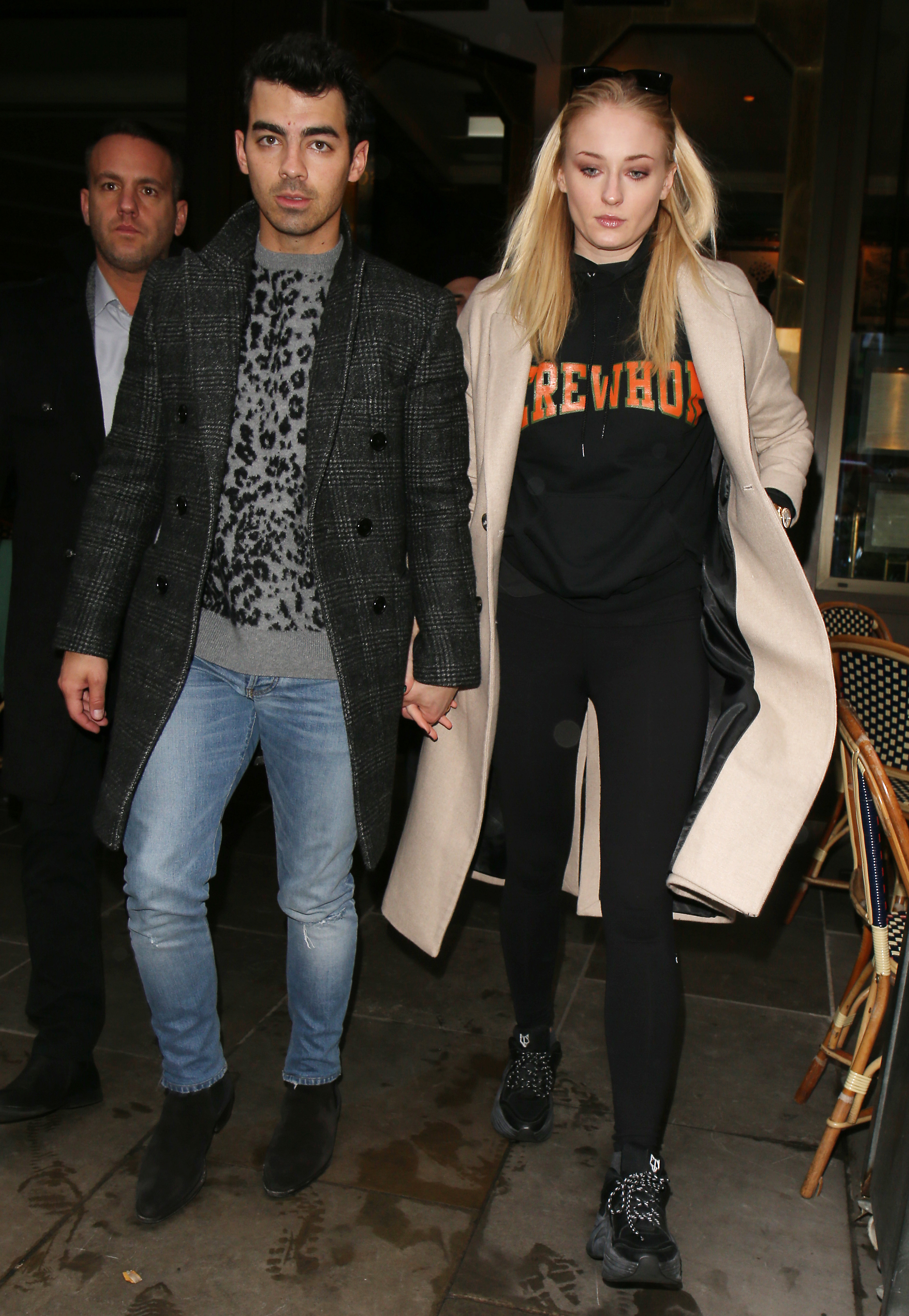 Joe Jonas Wears Jeans a Leopard Print Sweater and Long Coat Holding Hands With Wife Sophie Turner in Black Sweats and Tan Coat