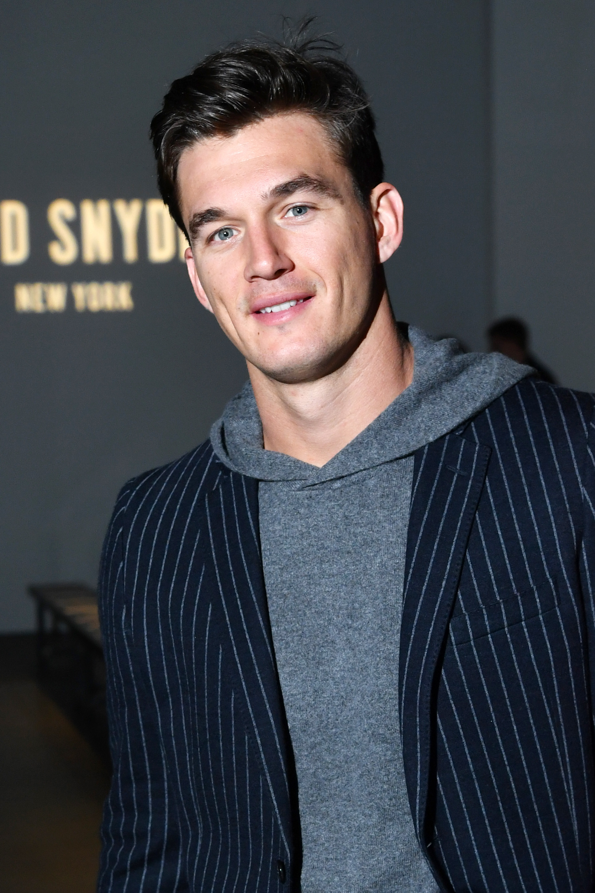 Tyler Cameron Wears Grey Hoodie with Blue Pinstripe Blazer on Top