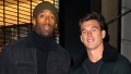 Tyler Cameron Wears Coat With Fur Collar standing Next to Matt James in Beanie and Black Coat
