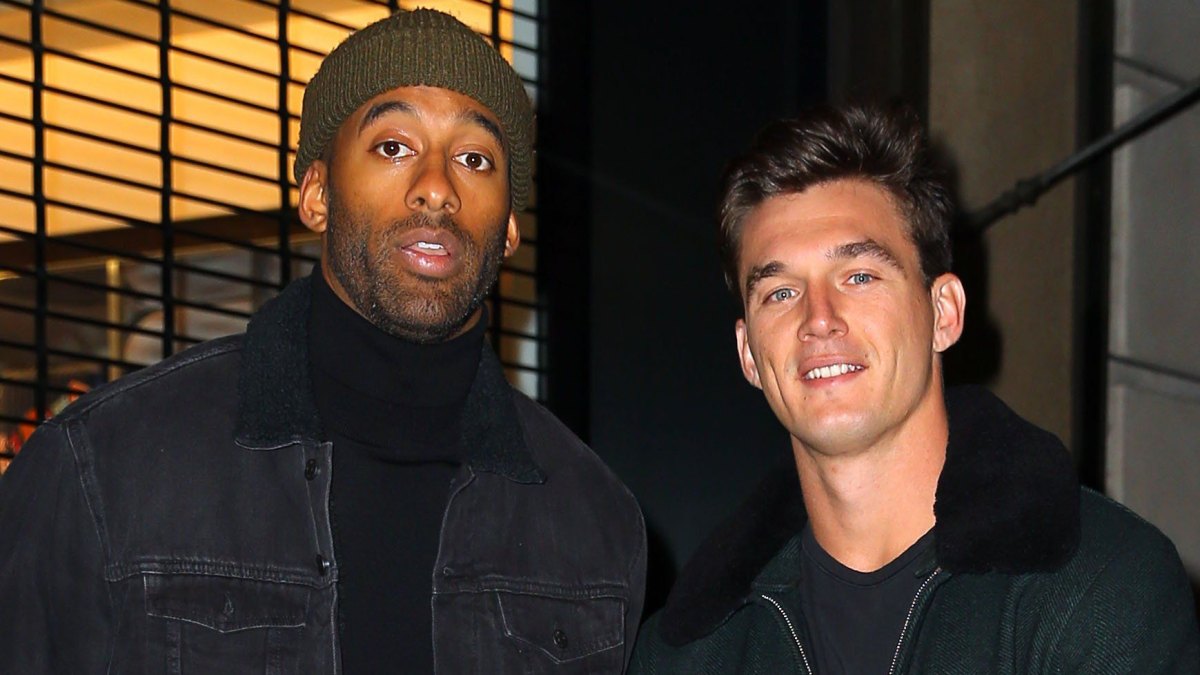 Tyler Cameron Wears Coat With Fur Collar standing Next to Matt James in Beanie and Black Coat