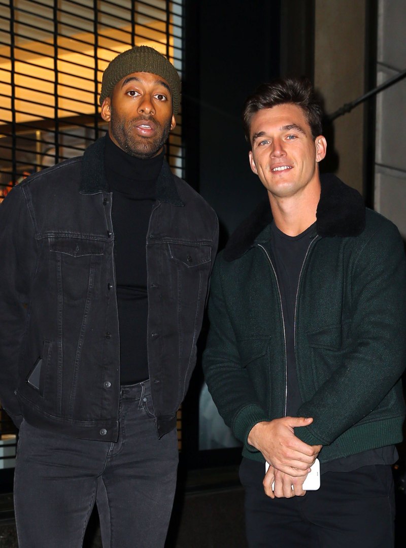 Tyler Cameron Wears Coat With Fur Collar standing Next to Matt James in Beanie and Black Coat