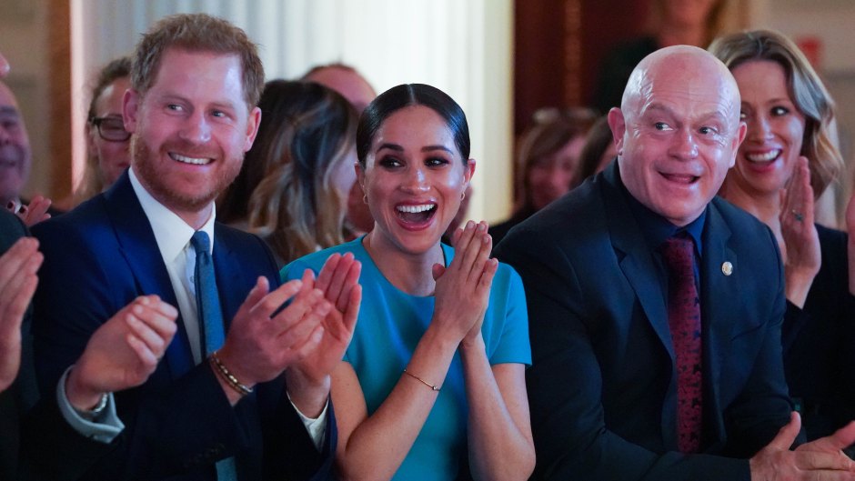 Meghan Markle Smiles and Claps in Blue Dress Sitting Next to Husband Prince Harry in Blue Suit