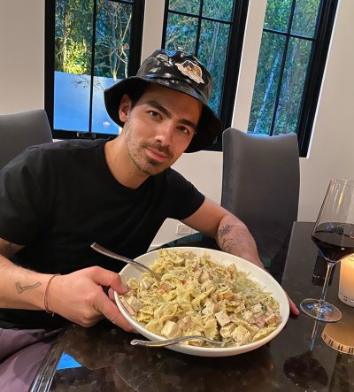 Joe Jonas Wears Bucket Hat and Tshirt Holding a Big Bowl of Pasta