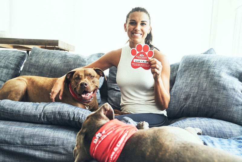 Soccer star Alex Morgan poses with her two rescue dogs