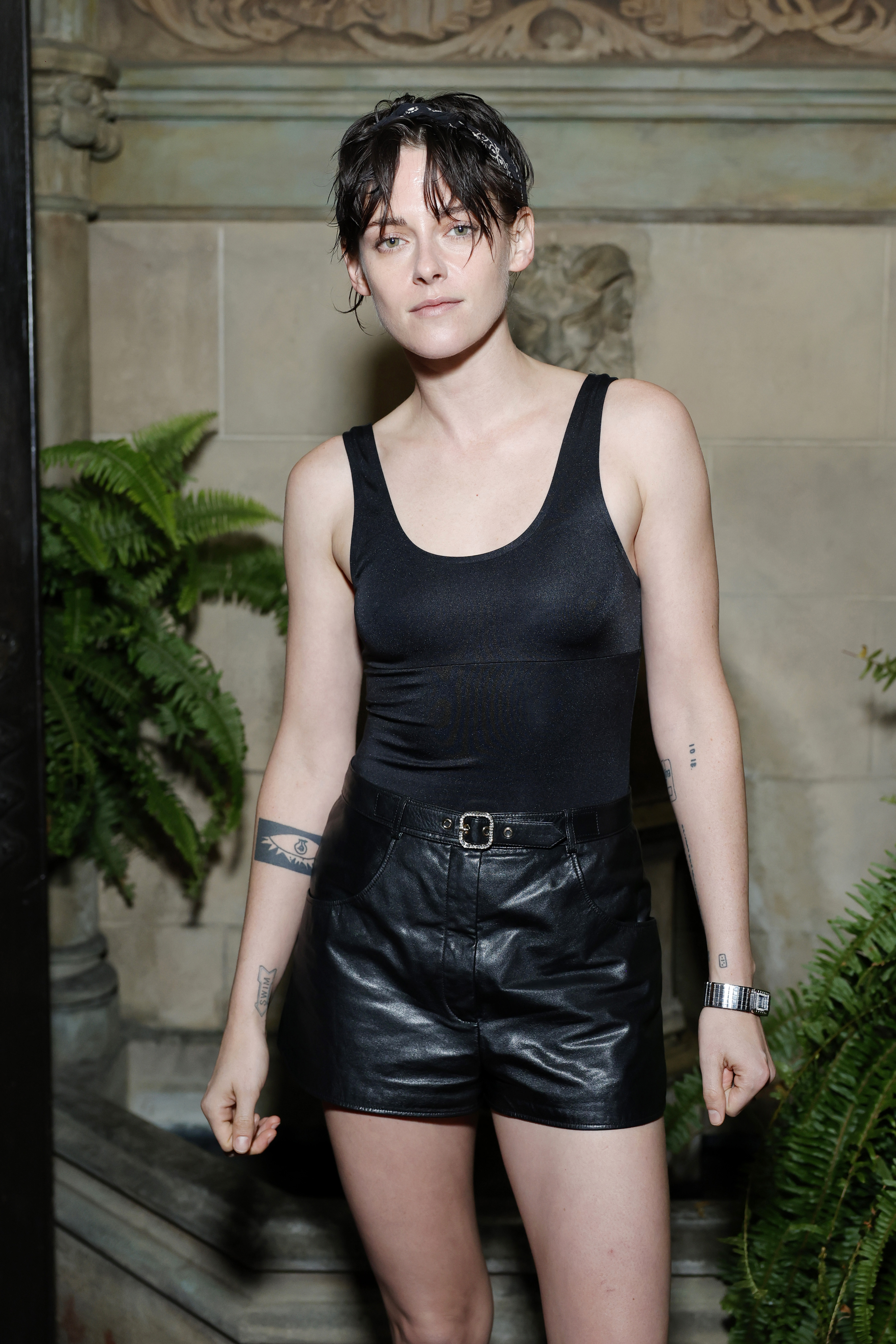 Kristen Stewart wearing a black tank top and black shorts at the Chanel dinner.